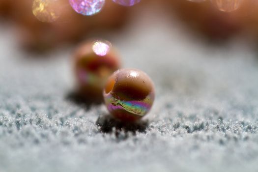 close up of beige colored beads shine under sunlight on blue towel in landscape orientation