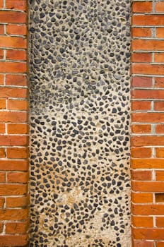 Architectural background. Interesting wall made of red brick and concrete with little stone in it.