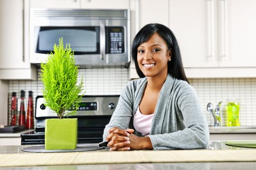 Smiling black woman in modern kitchen interior