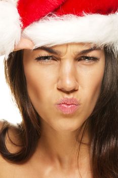 beautiful woman wearing santas hat looking angry on white background
