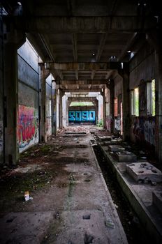 Abandoned, ugly building tunnel with graffiti and dust