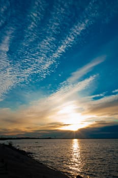 Colorful sunset with beautiful sky and stony beach