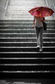 Girl with colorful umbrella going to metro