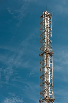 High industrial column and blue, clean sky