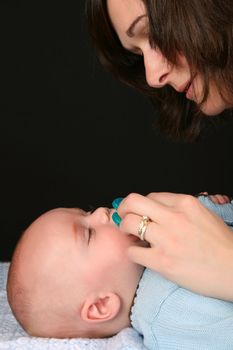 Brunette mother consoling her baby with a dummy