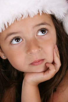 Beautiful brunette girl wearing a christmas hat, looking up