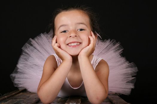 Cute brunette ballet girl wearing a pink ballet costume