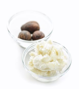 Shea butter and nuts in glass bowls isolated on white