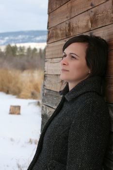 Beautiful brunette female against wooden barn background