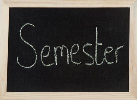 A black board with a wooden frame and the word 'SEMESTER' written in chalk.