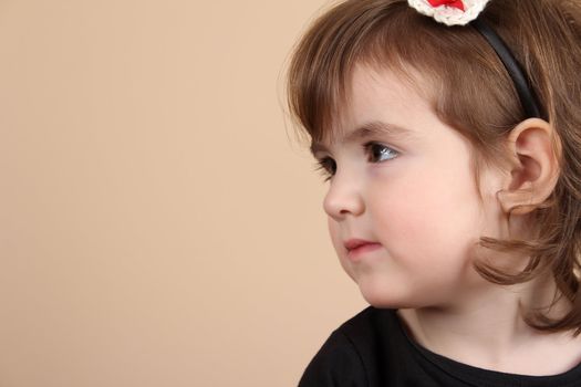 Cute little brunette toddler with serious expression 