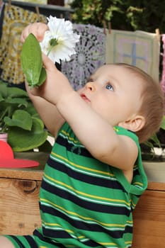 Cute baby boy outside in the garden wearing green outfit