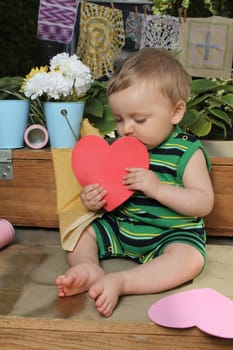Cute baby boy outside in the garden wearing green outfit