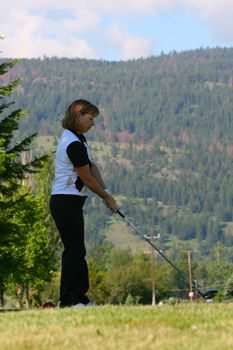 Female golfer preparing to drive the ball