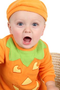 Baby dressed in a pumpkin costume on white background