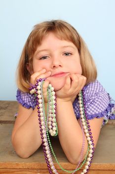 Cute little girl wearing a purple dress against blue background