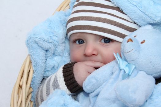 Cute baby boy lying outside in a basket