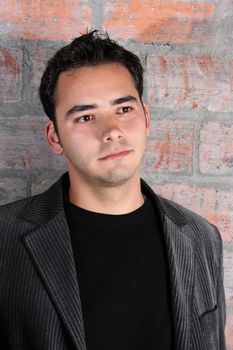 Male model against a rough brick wall background 