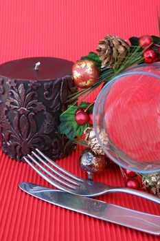 Christmas Table setting with cutlery, wine glass, candle and wreath