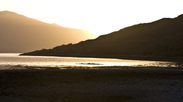 sunset over scottish mountains with loch