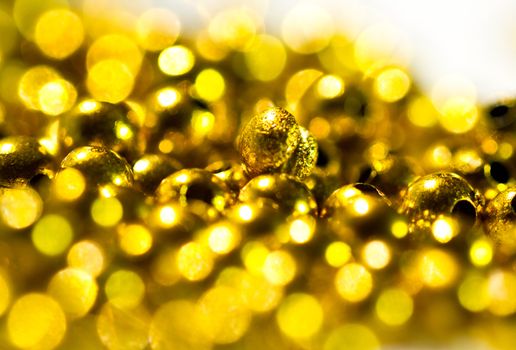 Golden plastic beads under the sun light with shallow DOF