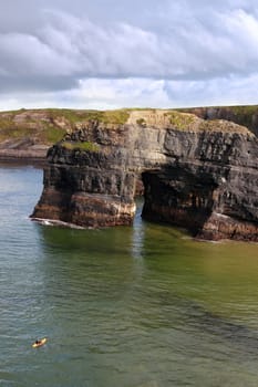 a canoeist at the virgin rock in ballybunion ireland as seen from the cliffs