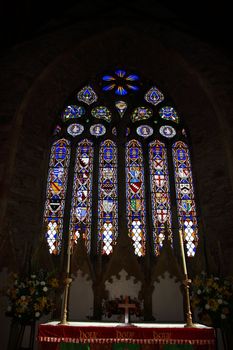 an alter and stained glass window in a church in cork ireland
