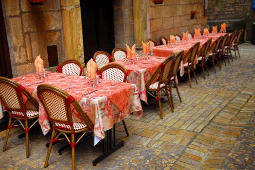 Outdoor restaurant patio on medieval street of Sarlat, Dordogne region, France