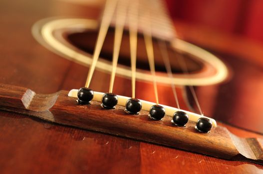 Acoustic guitar bridge and strings close up