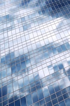 Reflection of a cloudy sky in glass wall of an office building