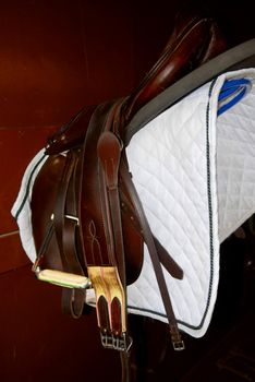 Saddle on a rack in a tack room, horseback riding equipment