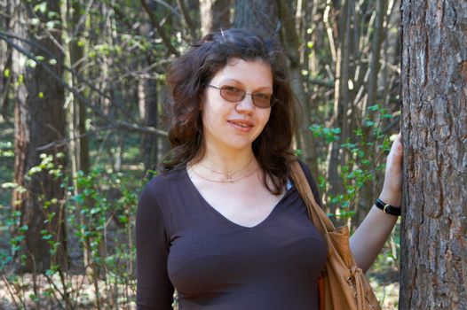 The pregnant woman walking in a forest