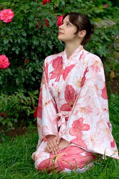 Girl in a pink yukata near rosebush
