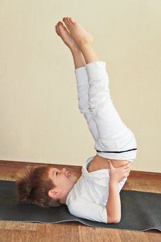 Baby yoga at home. Sarvangasana, candle pose