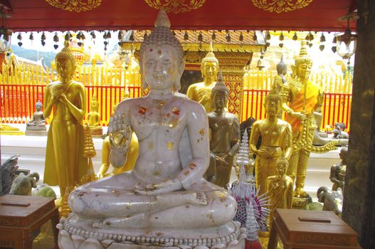 Au temple de Wat Phrathat Doi Suthep à Chiang Mai tous les bouddhas sont doré . Seuls quelque uns en marbre ou en bronze sont placés sur le chemin des fidèles . Les fidèles y colleront en offrande des petits carrés de feuille d’or .
