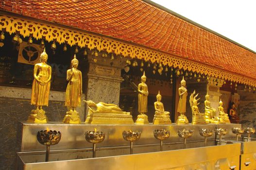 Position symboliques du Bouddha au temple de Wat Phrathat Doi Suthep . Un auge en inox remplie decire liquide d’où sortent de fleurs de lotus avec une mèche enflammée . Les fidèles s’arrêtent devant chaque Bouddha dans leur parcours pour prier et versent à l’aide d’une petite louche , un peu de cire liquide dans la fleur de lotus pour que la flamme continue à brûler .
Des clochette sont pendues au bord du toit . Elle tintent par le battant agité par le vent sur les feuilles d’or .