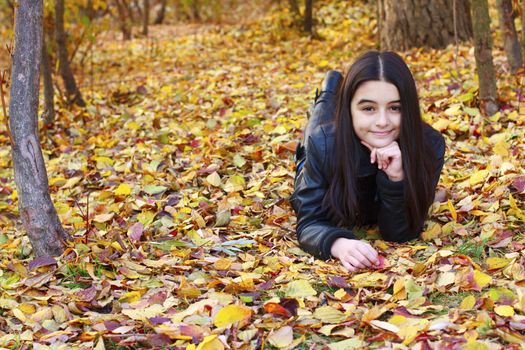 Teenager laying on leaf in the park-Autumn.