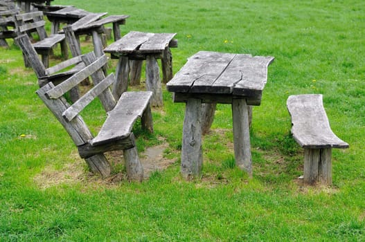 Old wooden bench on green grass in park