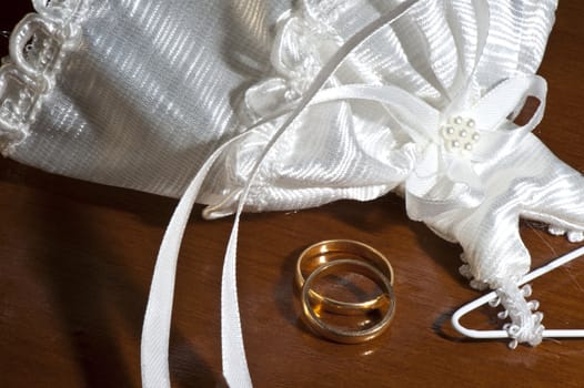 wedding favors and wedding rings on a dark wood table