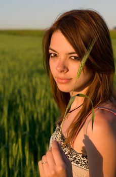 Smiling girl holding cereal crop 