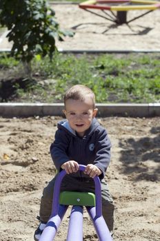 Little boy on a swing on a playground