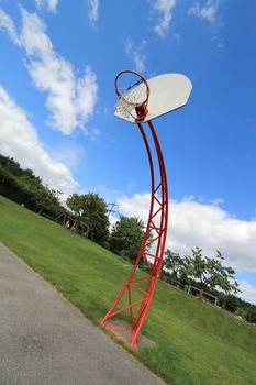 Red basket ball hoop on an out door court by cloudy weather