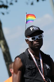 Black man wearing a cap with a rainbow flag on it while taking part in Gay Pride Parade 2011, Geneva, Switzerland