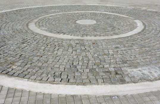 Two-colored paving stones creates circular pattern on a square