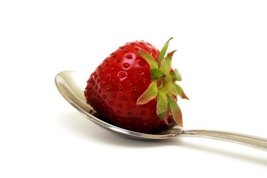 Zoomed foto of strawberry lying on melhior spoon