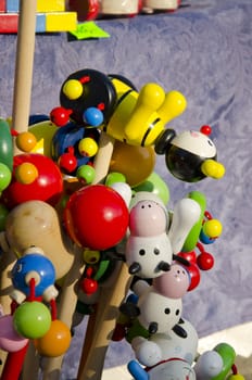 Colorful wooden toys on a stick. Home decorations sold in outdoor fair.