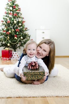 little girl and her mother holding gift at Christmas