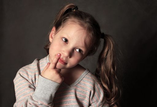 Portrait of the thoughtful girl of 5 years in studio