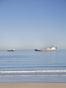 Shipping boats at sea near the beach