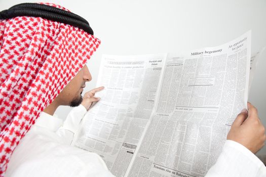Arab sheikh reading newspaper